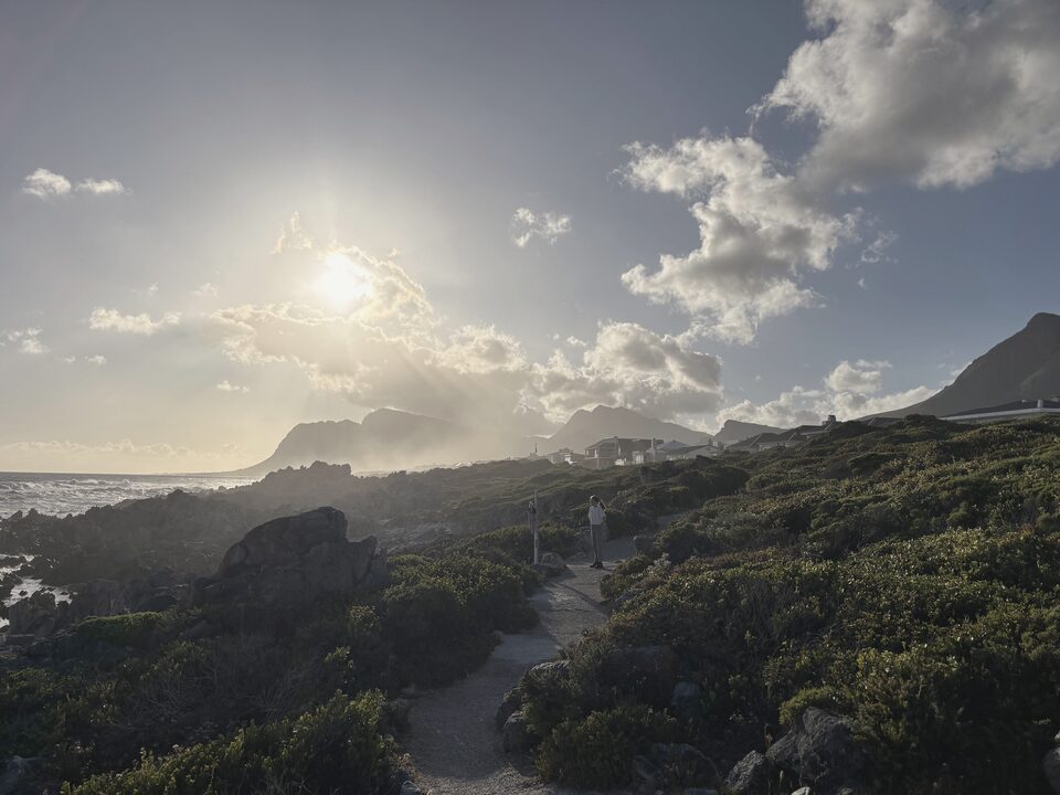A coastal path at dusk, low sun through cloud
